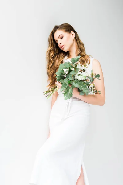 Elegante ragazza in vestito che tiene mazzo di fiori su bianco — Foto stock