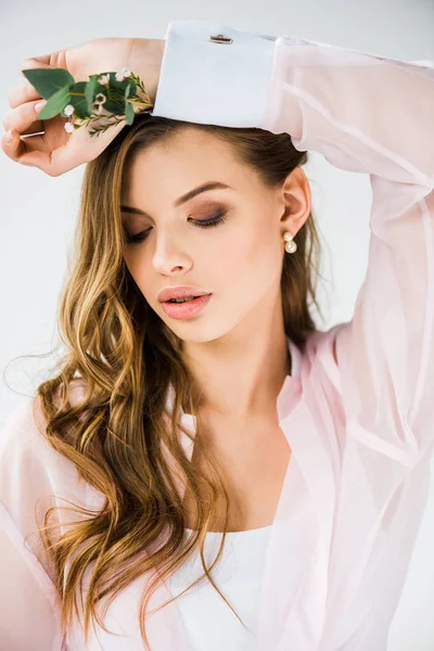 Hermosa chica con flores y hojas de eucalipto verde en la mano en blanco - foto de stock