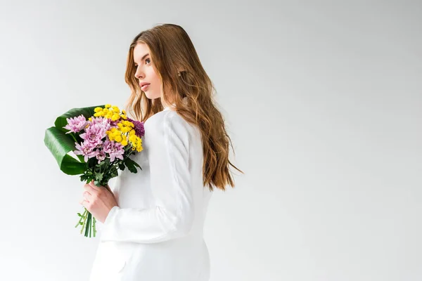 Мрійлива дівчина тримає букет з польових квітів на білому — стокове фото