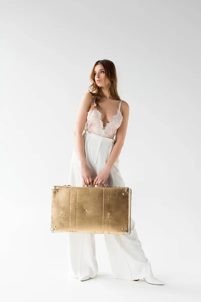 Stilvolles hübsches Mädchen mit Koffer im Stehen auf weiß — Stockfoto