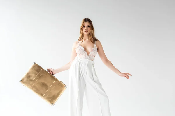 Красива жінка тримає дорожню сумку, стоячи на білому — стокове фото