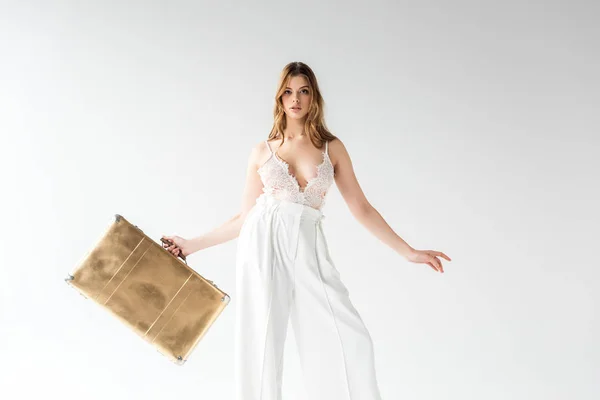 Beautiful woman holding travel bag while standing on white — Stock Photo