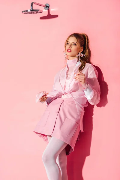 Attractive dreamy young woman standing on pink — Stock Photo