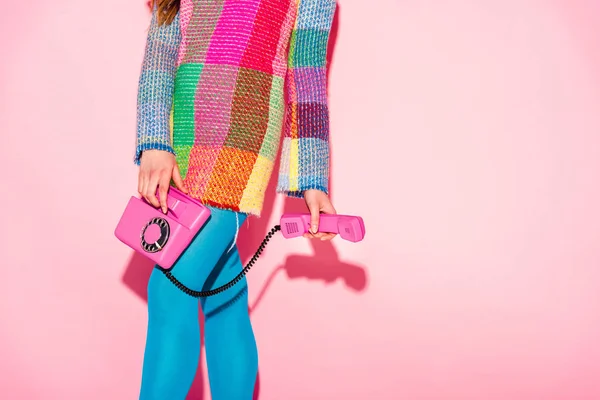 Cropped view of woman in checkered dress holding retro phone on pink — Stock Photo