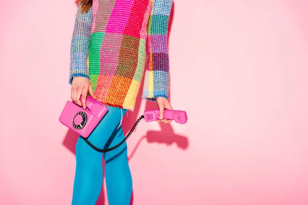 Recortado vista de la mujer en vestido a cuadros celebración de teléfono retro en rosa - foto de stock