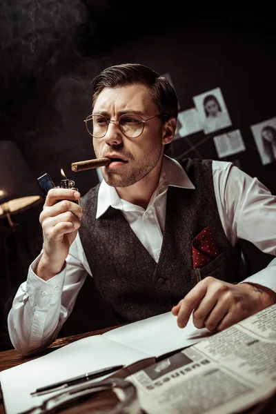 Detective in glasses and white shirt lighting cigar in dark office — Stock Photo