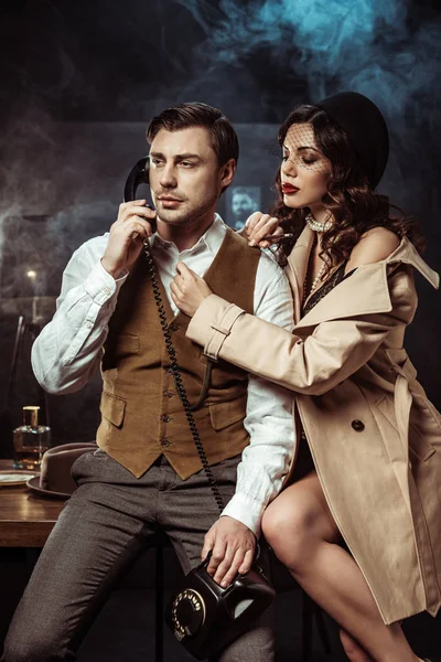 Mujer sexy en lencería y abrigo de trinchera seduciendo detective en la oficina - foto de stock