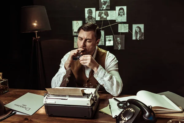 Detective in white shirt lighting cigar at table in office — Stock Photo