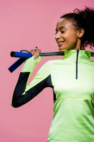 Beautiful african american sportswoman posing with skipping rope isolated on pink — Stock Photo