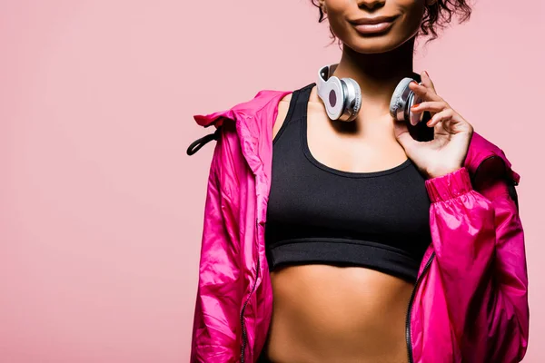 Vista recortada de esportista afro-americana com fones de ouvido isolados em rosa com espaço de cópia — Fotografia de Stock