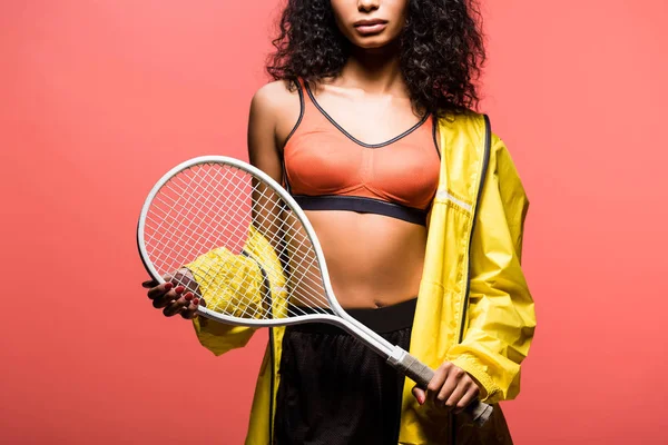 Обрізаний вид афроамериканської спортсменки тримає тенісну ракетку ізольовано на коралі — стокове фото