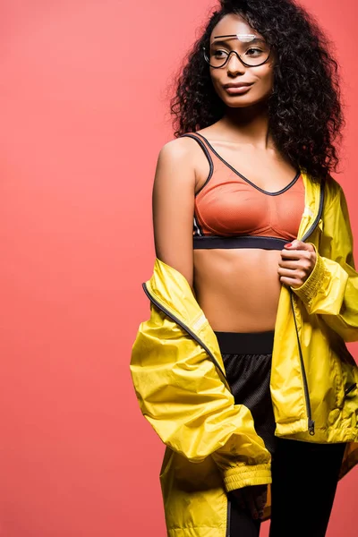 Beautiful african american sportswoman in glasses posing isolated on coral with copy space — Stock Photo