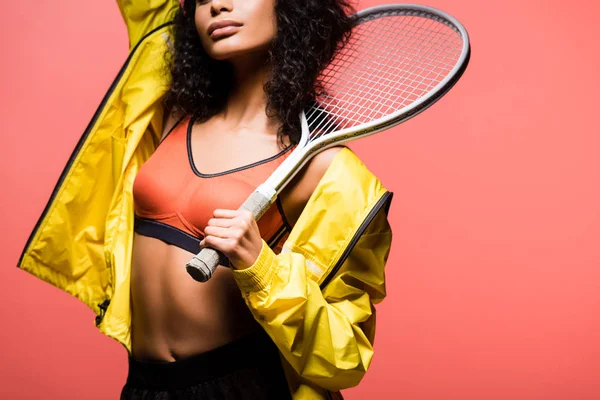 Vista ritagliata della sportiva afro-americana che tiene la racchetta da tennis isolata sul corallo — Foto stock