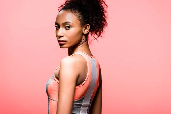 Beautiful african american sportswoman looking at camera and posing isolated on coral with copy space — Stock Photo