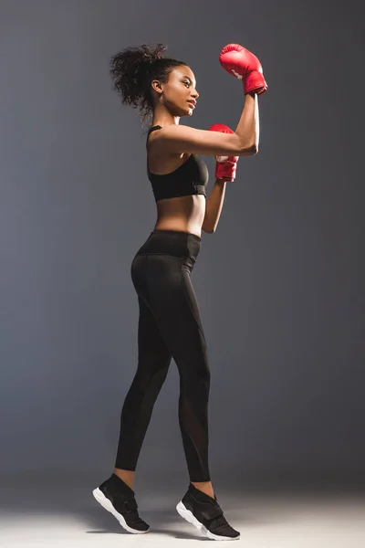 Belle sportive africaine américaine sportive en gants de boxe sur noir — Photo de stock