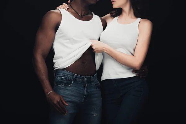 Обрізаний вид жінки, що роздягається м'язистий афроамериканський чоловік ізольований на чорному — стокове фото