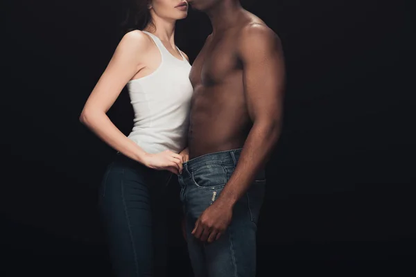 Cropped view of seductive interracial couple isolated on black with copy space — Stock Photo