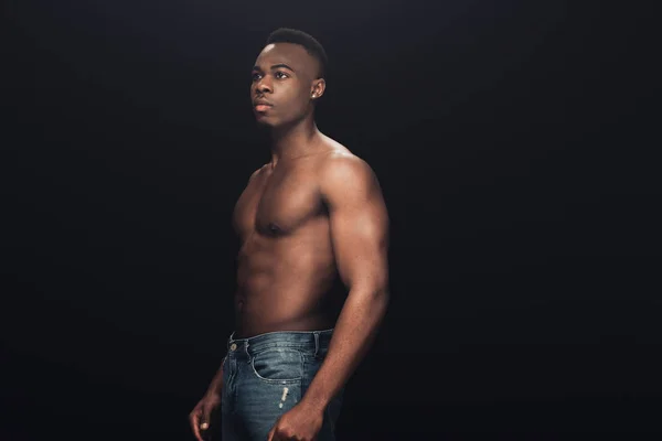 Bel homme africain américain torse nu en denim posant isolé sur noir avec espace de copie — Photo de stock