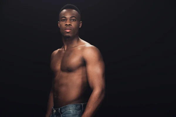 Schöner hemdloser afrikanisch-amerikanischer Mann in Jeans, der isoliert auf schwarz mit Kopierraum in die Kamera schaut — Stockfoto