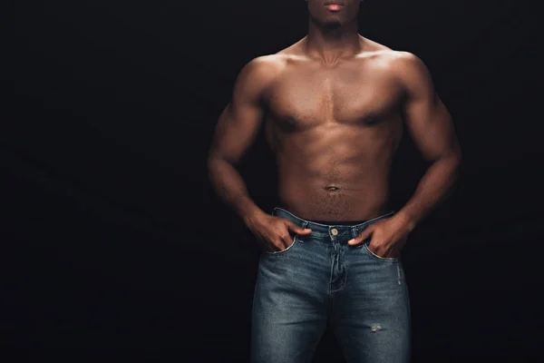 Vista parziale di sexy muscolare uomo africano americano in denim posa isolata su nero con spazio copia — Foto stock