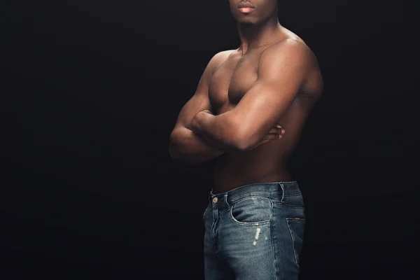 Cropped view of sexy muscular african american man in denim posing with crossed arms isolated on black — Stock Photo