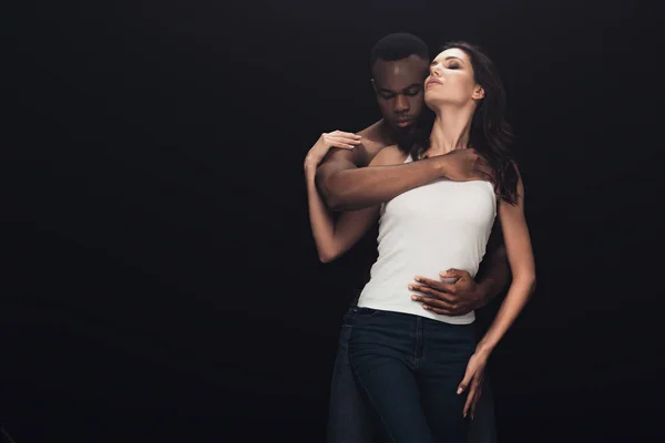 African american man embracing attractive woman isolated on black with copy space — Stock Photo