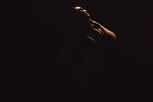 Silhouette of sensual woman isolated on black with copy space — Stock Photo