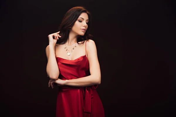 Beautiful sensual woman in red dress posing isolated on black with copy space — Stock Photo