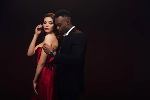 Beautiful sensual interracial couple in formal wear posing isolated on black with copy space — Stock Photo