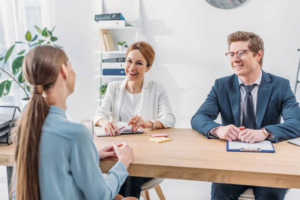 Back view of employee speaking with cheerful recruiters during job interview — Stock Photo