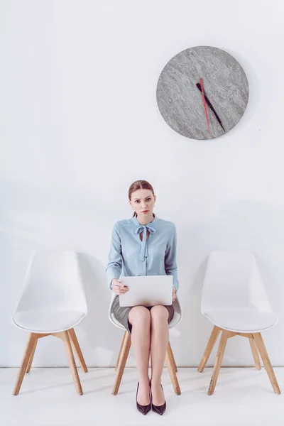 Attractive employee sitting on chair with laptop while waiting job interview — Stock Photo