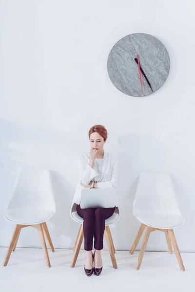 Dipendente pensieroso seduto sulla sedia con laptop e colloquio di lavoro in attesa — Foto stock