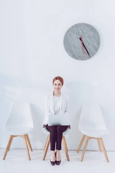 Employé joyeux assis sur la chaise avec ordinateur portable en attendant entrevue d'emploi — Photo de stock