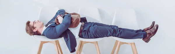 Panoramic shot of employee lying on chairs while waiting job interview — Stock Photo