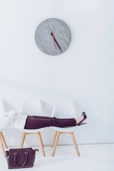 Cropped view of woman lying on chairs while waiting job interview — Stock Photo