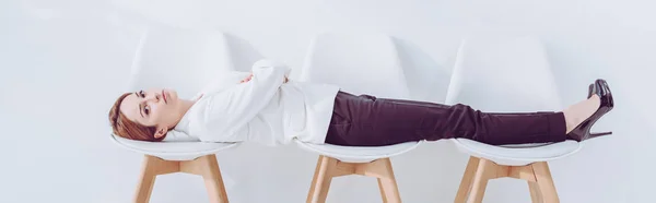 Tiro panorâmico de empregado deitado em cadeiras enquanto espera entrevista de emprego — Fotografia de Stock