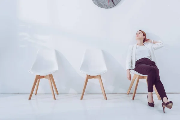 Atractivo empleado sentado en silla y esperando entrevista de trabajo - foto de stock