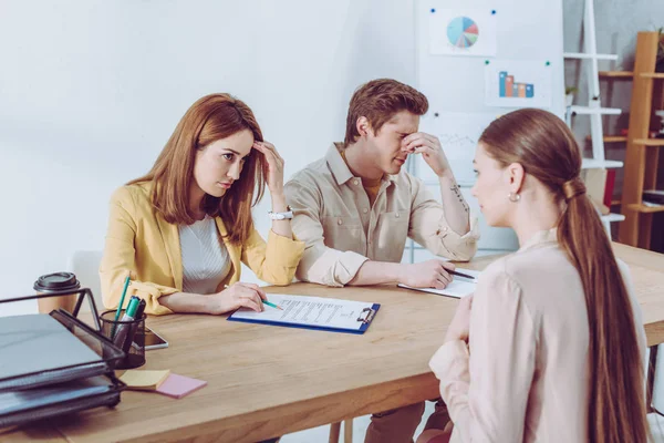 Bel homme couvrant visage près attrayant recruteur regardant femme sur l'entrevue d'emploi — Photo de stock