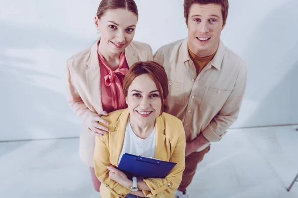 Overhead view of happy man and women looking at camera — Stock Photo
