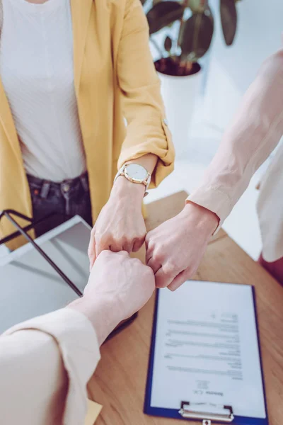 Cropped view of supportive group giving fist bump in office — Stock Photo