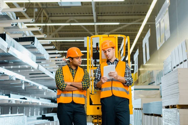 Concentration sélective des travailleurs concentrés utilisant un ordinateur portable numérique dans un entrepôt — Photo de stock
