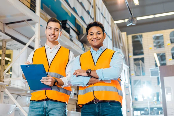 Smiling multicultural warehouse workers smiling and looking at camera — Stock Photo
