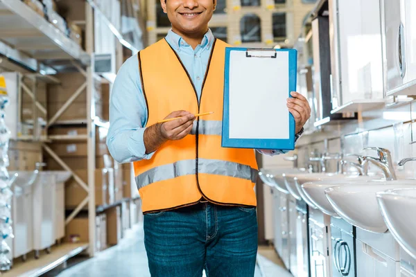Partial view of indian worker pointing at clipboard with blank paper — Stock Photo