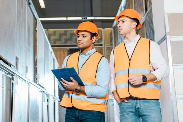 Attentive multicultural colleagues working in tiles department in warehouse — Stock Photo