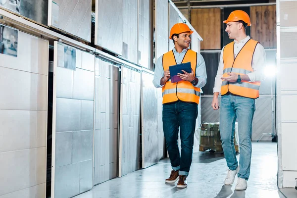 Alegres trabajadores de almacenes multiculturales hablando en el departamento de azulejos — Stock Photo