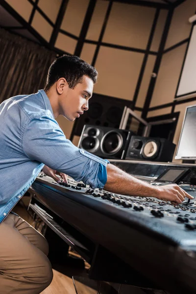 Ernsthafter Mixed Race Soundproduzent, der im Tonstudio arbeitet — Stockfoto