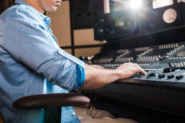 Visão parcial do produtor de som de raça mista que trabalha no console de mixagem no estúdio de gravação — Fotografia de Stock