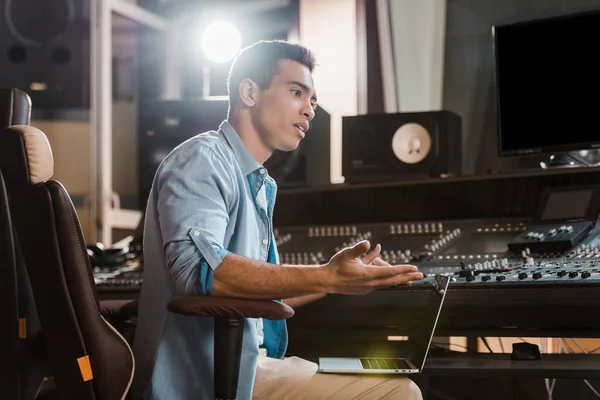 Bello concentrato razza mista produttore di suoni che lavorano in studio di registrazione a mixare console — Foto stock