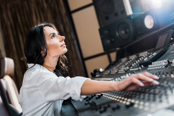Pretty smiling musician working in recording studio at mixing console in recording studio — Stock Photo