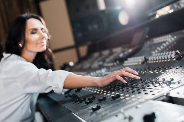 Selective focus of attractive sound producer working on mixer console — Stock Photo